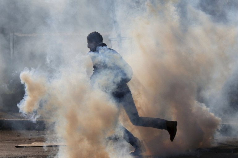 A Palestinian protester runs for cover from tear gas fired by Israeli troops during clashes in the West Bank city of Bethlehem [REUTERS]