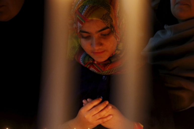 A girl prays for the victims of a militant attack on the Bacha Khan University, during a candle light vigil in Peshawar, Pakistan [REUTERS]
