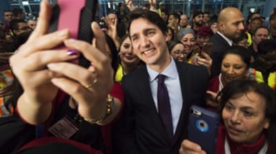 Canadian Prime Minister Justin Trudeau poses for selfies with workers before he greets refugees from Syria in Toronto [AP]