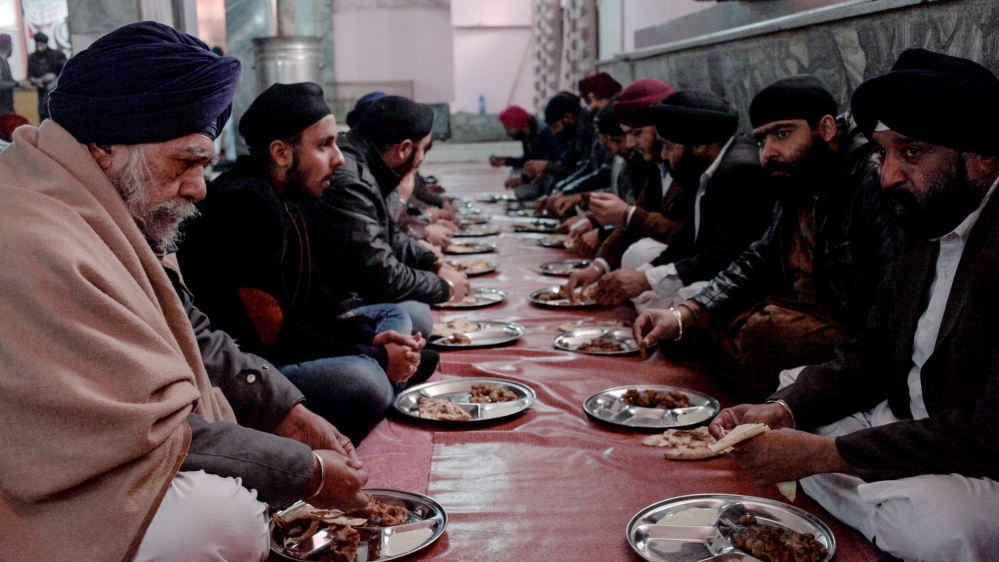 
Afghan Sikhs eat breakfast together at the langar in mid-December; the small community come together every month to share a communal meal [Sune Engel Rasmussen/Al Jazeera]
