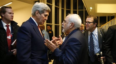 John Kerry, the US secretary of state, talks with Mohammad Javad Zarif, the Iranian foreign minister, after the IAEA verified that Iran has met all conditions under the nuclear deal, in Vienna [AP]