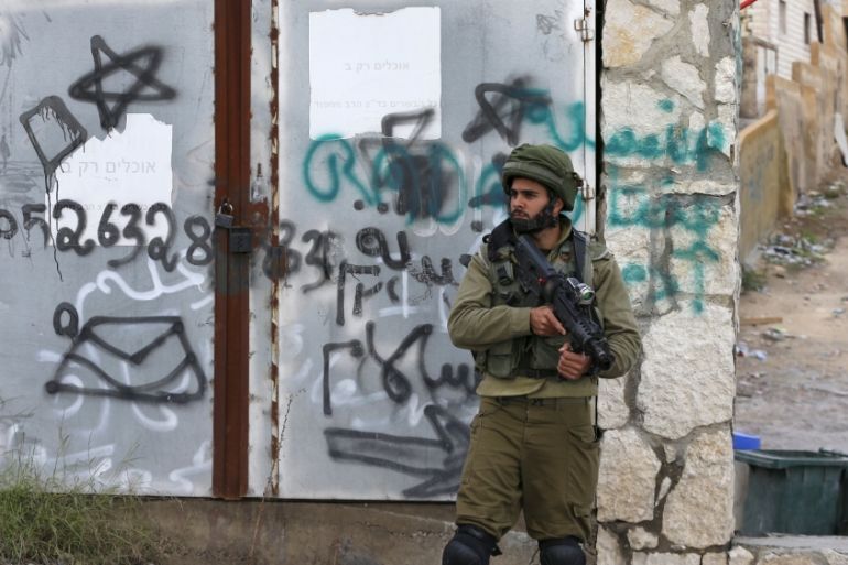 An Israeli soldier stands guard near scene of what Israeli military said was a Palestinain shooting attack in West Bank, at an Israeli checkpoint near Hizma