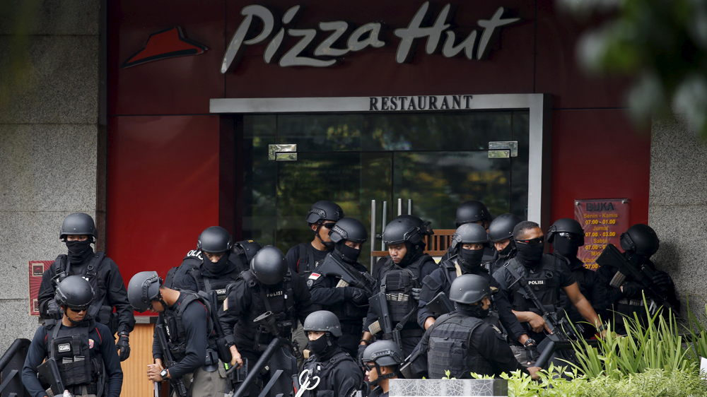 Police gathered outside a restaurant near the scene of an attack in central Jakarta [Beawiharta/Reuters]