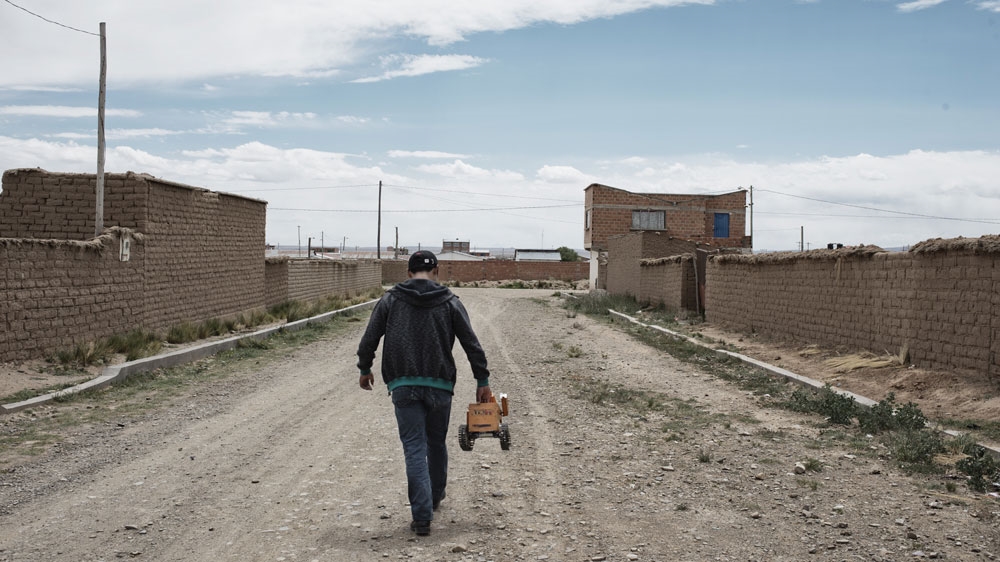 Quispe walks from his home to the nearby waste dump with his robot Wall-E [Valentino Bellini/Al Jazeera]