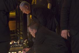 Israeli Prime Minister Benjamin Netanyahu lights a candle during a visit to the scene of a shooting incident in Tel Aviv, Israel