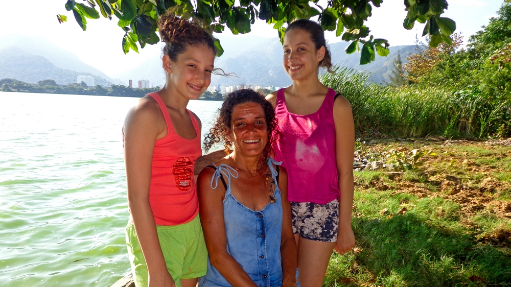 Sandra with her two youngest daughters. Perola Luz, left, is 11. Flora Terra is 14. Both have lived in Vila Autodromo all their lives [Maya Thomas-Davis/Al Jazeera] 