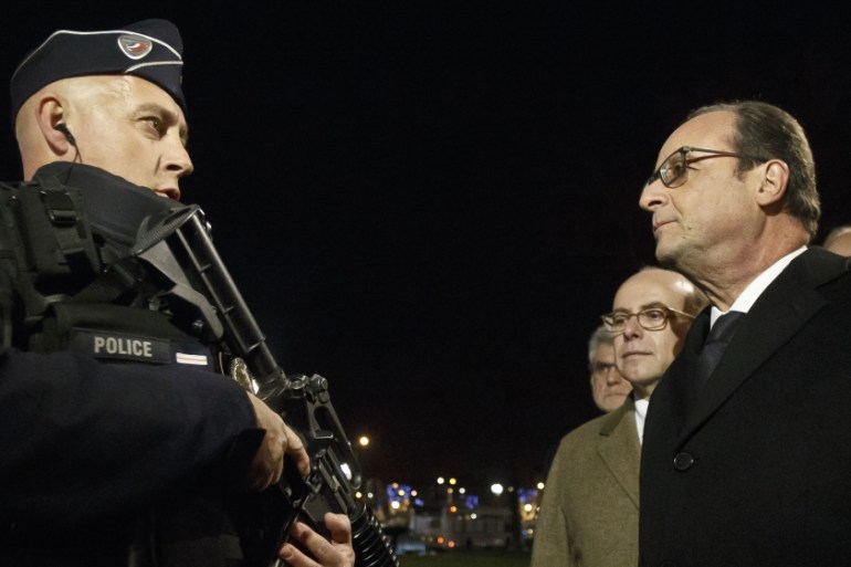 France''s President Francois Hollande, right, talks to an armed police officer as he visits the security measures at the Champs Elysees in Paris [AP]