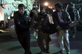 A wounded man is being carried from the site of a blast near the Kabul international airport, Afghanistan