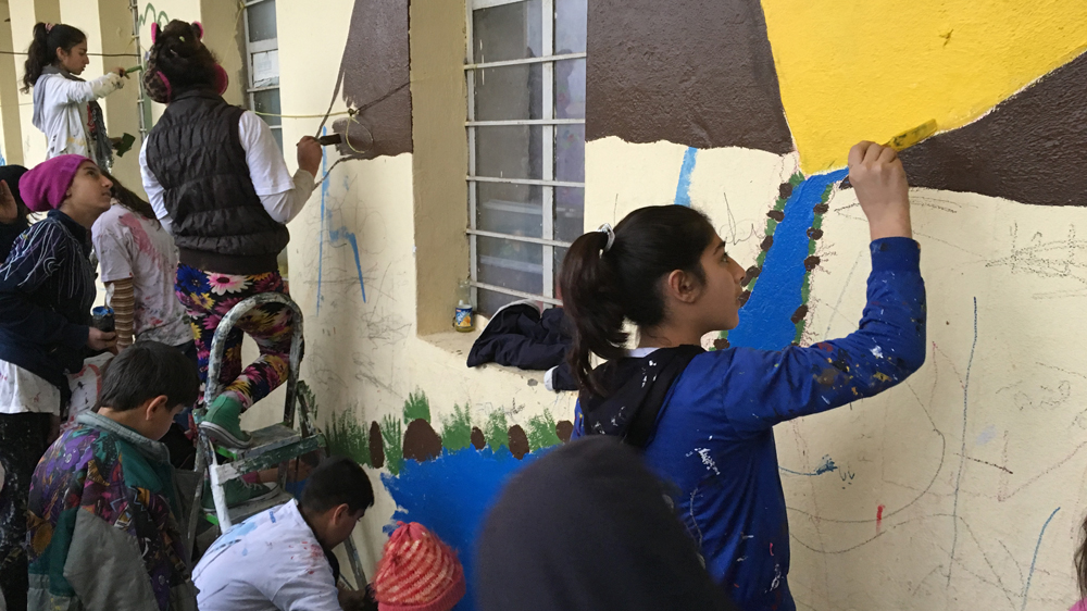 Hanan, right, says painting has helped tremendously and made her feel much better [Mohammed Jamjoom/Al Jazeera]