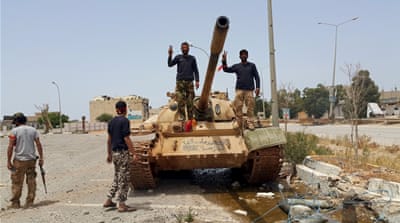 
Members of the Libyan pro-government forces gesture as they stand on a tank in Benghazi, Libya [REUTERS]
