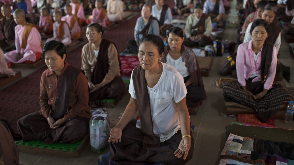 Buddhist laywomen and nuns meditate during an early-morning class at the Thabarwa Meditation Center [Will Baxter/Al Jazeera] 