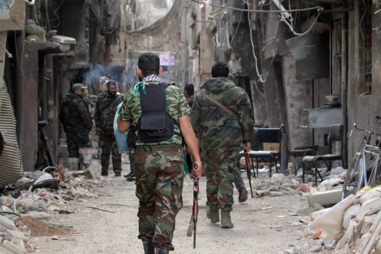Palestinian fighters are seen walking at Palestine Camp near Damascus