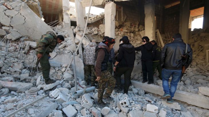Kurdish fighters from the People''s Protection Units (YPG) inspect damage at a site hit by one of three truck bombs, in the YPG-controlled town of Tel Tamer, Syria