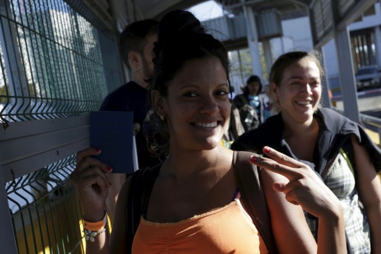 A Cuban migrant poses for a picture as she crosses a pedestrian bridge to Laredo, US [REUTERS]