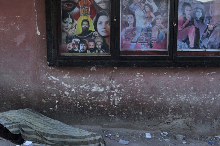 An Afghan man rests near a cinema in Kabul [AFP]