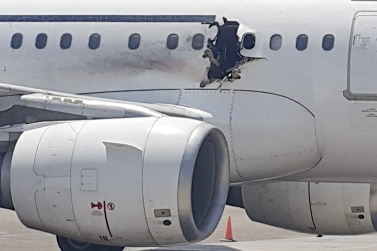 In this Tuesday, Feb. 2, 2016 photo, a hole is photographed in a plane operated by Daallo Airlines as it sits on
