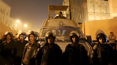 Riot police officers stand guard in front of the Cairo Security Directorate as hundreds of protesters gather in front of the building [Reuters]