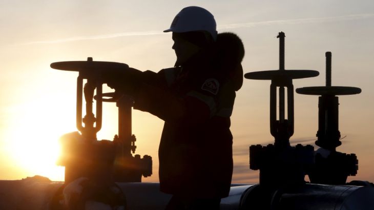 Worker checks valve of oil pipe at Lukoil company owned Imilorskoye oil field outside West Siberian city of Kogalym
