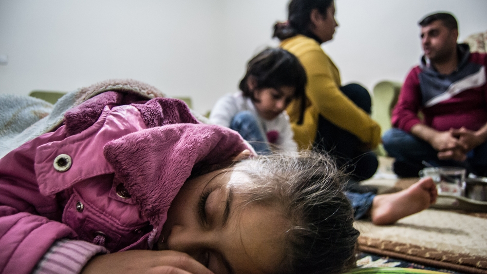 Departure is postponed again. Ariana falls asleep while her parents search for solutions to their financial woes [Pieter Stockmans/Al Jazeera]