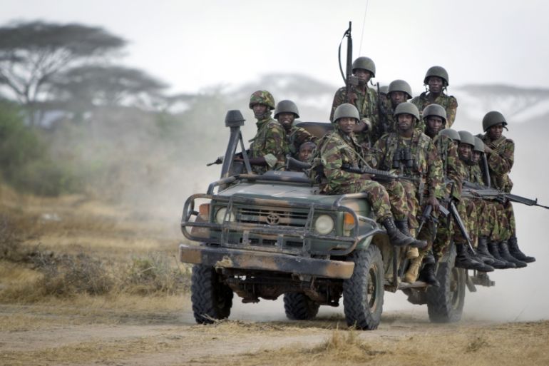 Kenyan army soldiers ride on a vehicle at their base in Tabda, inside Somalia.