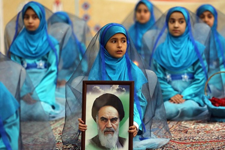 A young Iranian girl holds a portrait of the founder of Iran''s Islamic Republic, Ayatollah Ruhollah Khomeini [AFP]