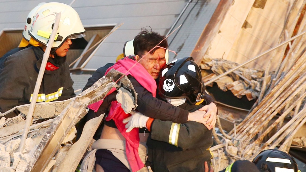 Rescue workers carry out a man from the rubble after Saturday's 6.4 magnitude quake [Reuters]