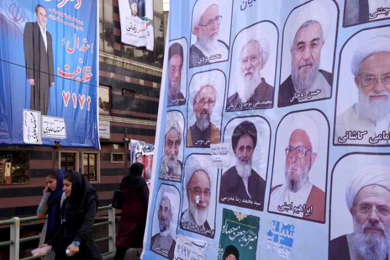 File photo of women walking past electoral posters for the upcoming elections in central Tehran