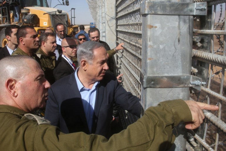 Netanyahu and IDF Chief of Staff Gadi Eizenkott, left, visit the construction work on the fence between Israel and Jordan
