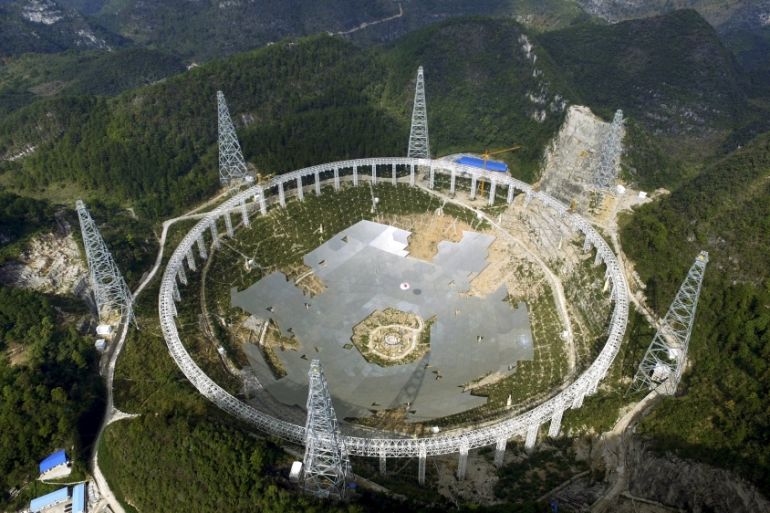 A 500-metre (1,640-ft.) aperture spherical telescope (FAST) is seen under construction among the mountains in Pingtang county