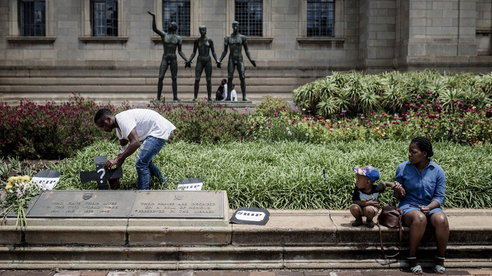Protesting students plant cardboard tombstones in potplants near the Great Hall at Wits. The words say RIP and show the amount of debt they owe the university [Cornel van Heerden/Al Jazeera]