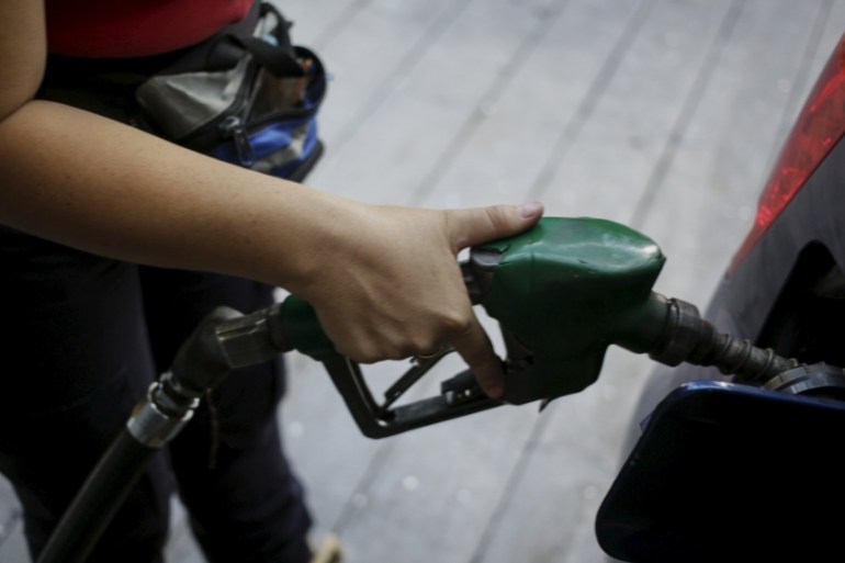 A worker pumps gas into a vehicle at a gas station, which belongs to Venezuela''s state oil company PDVSA, in Caracas