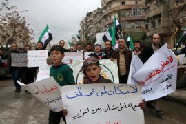 Residents carry banners and opposition flags as they march during a protest in Aleppo, asking for the release of prisoners held in government jails, in al-Fardous neighbourhood of Aleppo