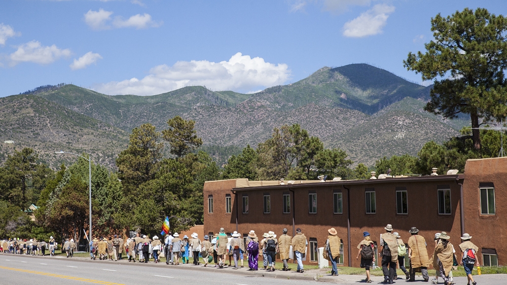 Activists walk up Trinity drive in Los Alamos to commemorate the 70th anniversary of Hiroshima and Nagasaki and to protest against the nationwide nuclear modernisation campaign that is taking place in the country today [ Gabriela Campos/Al Jazeera]