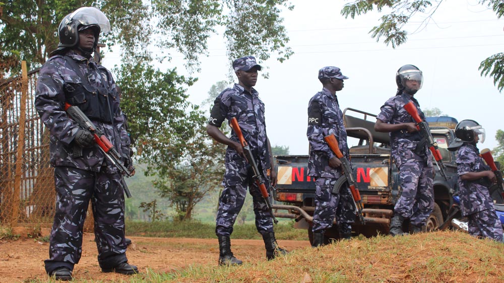 Police surround the entrance to Kizza Besigye's house in Kasangati as a way of keeping the opposition leader under preventative arrest [Tendai Marima/Al Jazeera] 