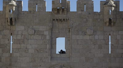 An Israeli anti-riot police sniper observes the surroundings from a wall of the Damascus Gate in the old city district of Jerusalem [EPA]