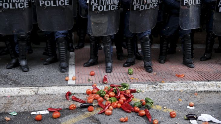 Vegetables are thrown in front of riot policemen guarding the Agriculture Ministry during a protest of Greek farmers against planned pension reforms in Athens
