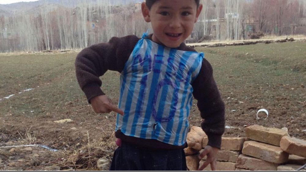 Murtaza Ahmadi plays football in an improvised Lionel Messi jersey made out of plastic [Homayoun Ahmadi]