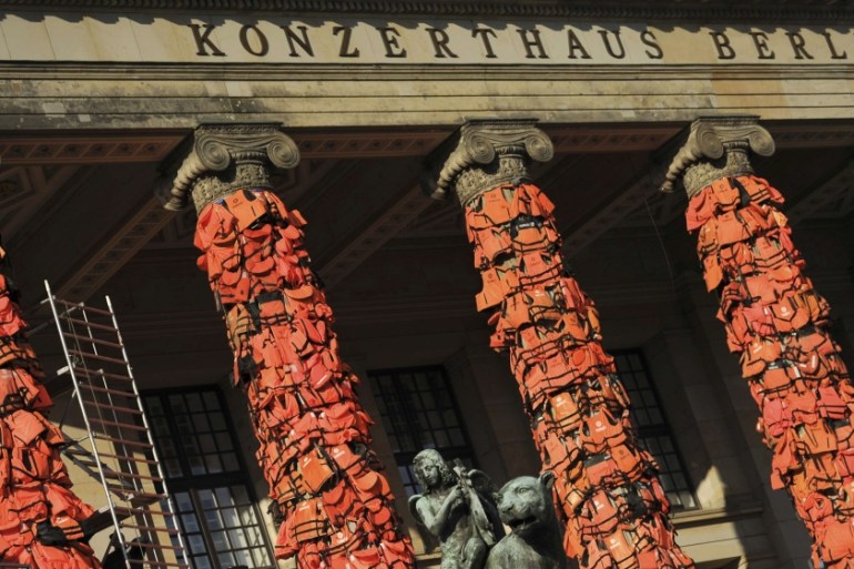 Workers bulid up an instalation by Chinese artist Ai Weiwei with life jackets left by migrants on Greek beaches on columns at the Schauspielhaus concert hall in Berlin