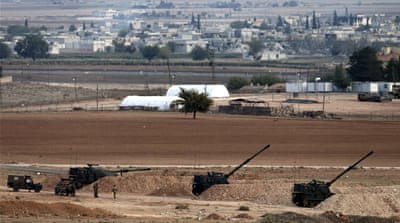 Turkish Army T-155 howitzers stand in firing position as they guard near the Turkish-Syrian border [EPA]