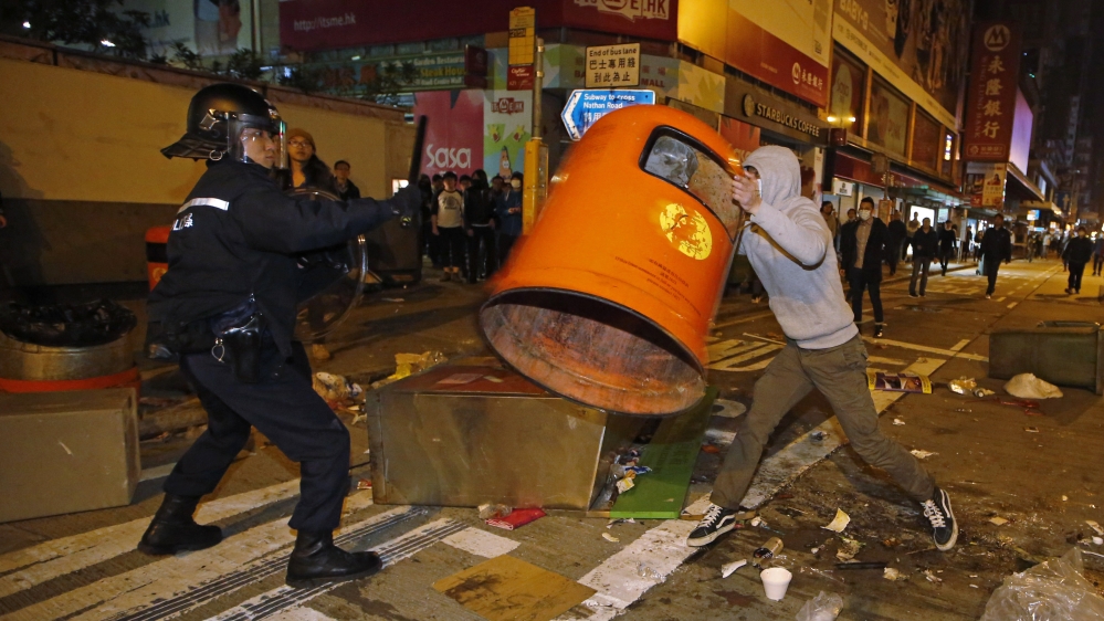 A rioter tries to throw a rubbish bin at police on a street in the Mong Kok district of Hong Kong [Kin Cheung/AP]Hong Kong's Lunar New Year celebrations descended into chaotic scenes as police fired warning shots into the air [Kin Cheung/AP]A protester shouts as he is arrested by police in plain clothes [Liau Chung-ren/Reuters]Bricks litter the streets after police clashed with protesters at the city's Mongkok district [Liau Chung-ren/Reuters]