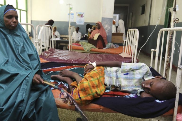 Woman comforts her child who is recovering from effects of drinking contaminated water from a well, at a hospital in Yaqshid district in Somalia''s capital Mogadishu
