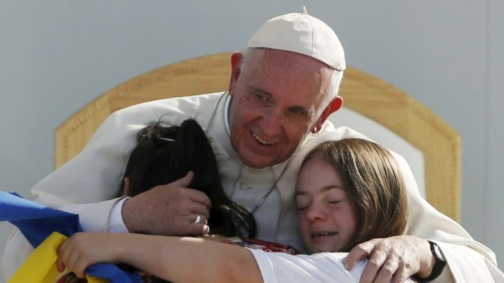 Pope Francis hugs two girls during a meeting with youths at the Jose Maria Morelos y Pavon stadium in Morelia