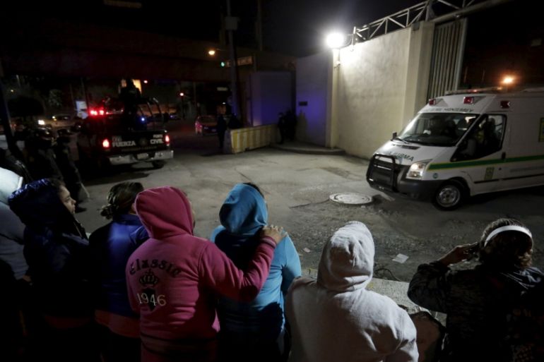 Family members of inmates stand outside Topo Chico Prison as an ambulance leaves the compound in Monterrey, Mexico, February 11, 2016.