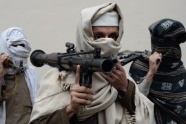 Former Afghan Taliban fighters carry their weapons before handing them over as part of a government peace and reconciliation process at a ceremony in Nangarhar province [AFP]