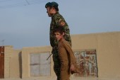 A wounded Afghan boy walks with an Afghan soldier at the site of a suicide attack in Mazar-i-Sharif [Getty]