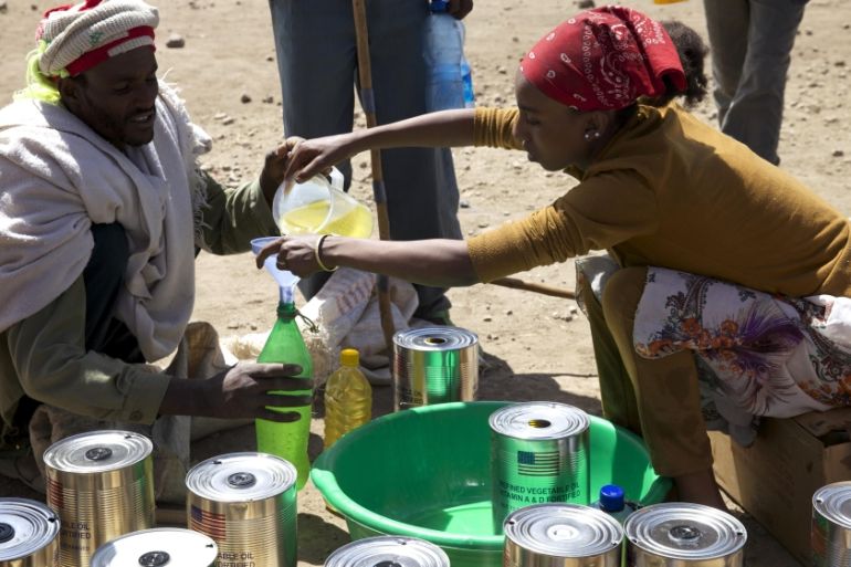 A man receives cooking oil at an emergency food aid distribution in the village of Estayish in Ethiopia''s northern Amhara region