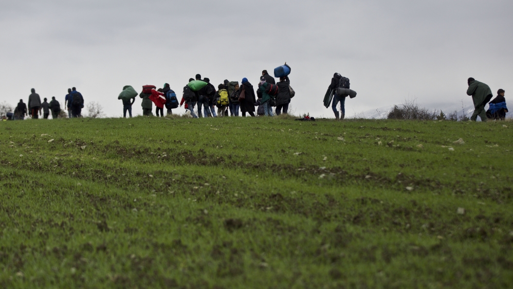 Refugees and migrants attempt to reach Macedonia on a route that would bypass the border fence on Monday [Visar Kryeziu/AP]