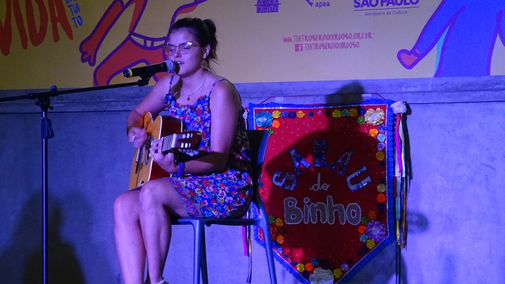 A singer-songwriter performing at Sarau do Binho [Kathleen McCaul/Al Jazeera]