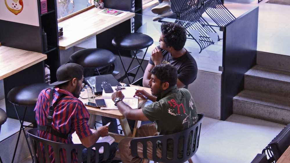 A group of students get together at Tea Villa Cafe in Bandra to use the wi-fi connection [Behdad Mahichi/Al Jazeera] 