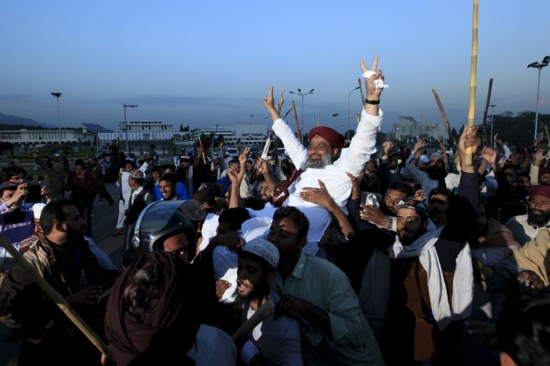Islamist activists carry one of their party leader on their sholders during a sit in protest against the execution of Mumtaz Qadri outside the Parliament building in Islamabad